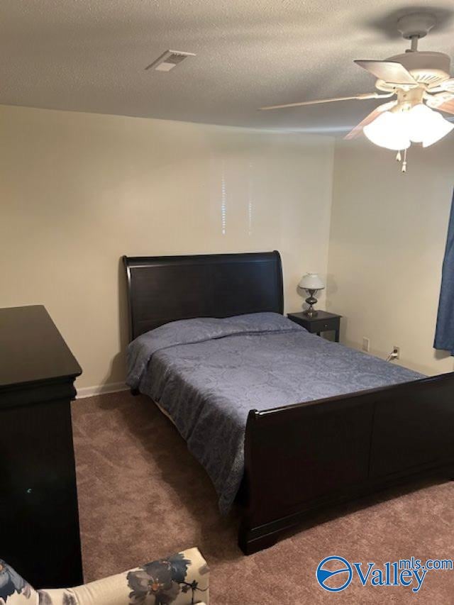 carpeted bedroom featuring a textured ceiling and ceiling fan