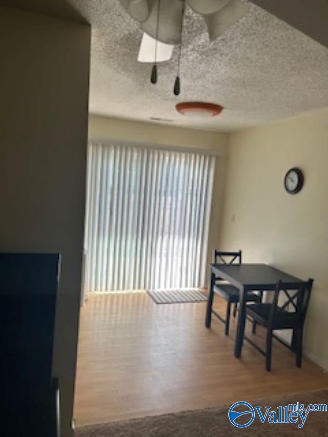 dining room featuring a textured ceiling and hardwood / wood-style floors