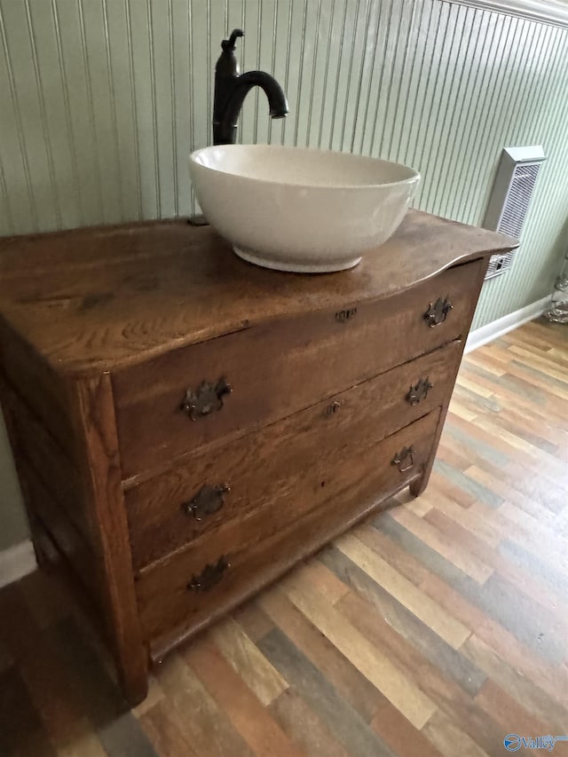 interior details featuring wood finished floors, vanity, and baseboards