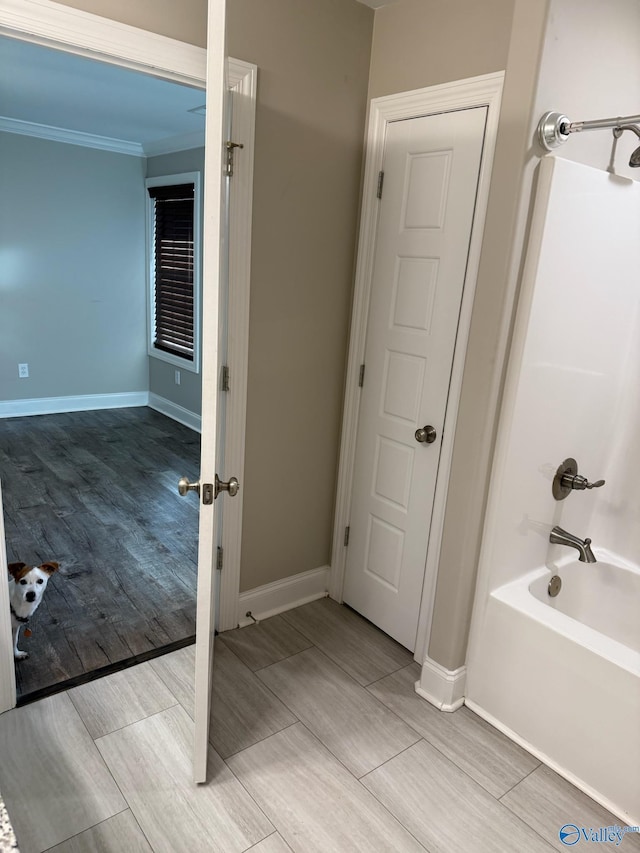 bathroom with shower / bathing tub combination and ornamental molding