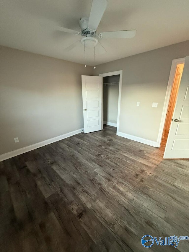 unfurnished bedroom with ceiling fan, dark wood-type flooring, and a closet