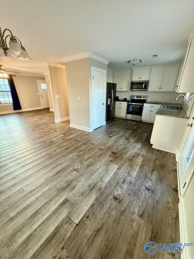 kitchen with white cabinetry, sink, crown molding, appliances with stainless steel finishes, and hardwood / wood-style flooring