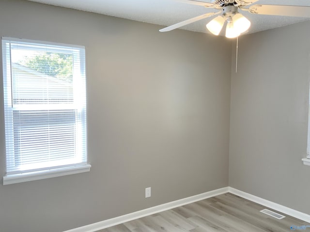 empty room with light hardwood / wood-style flooring, a textured ceiling, and ceiling fan