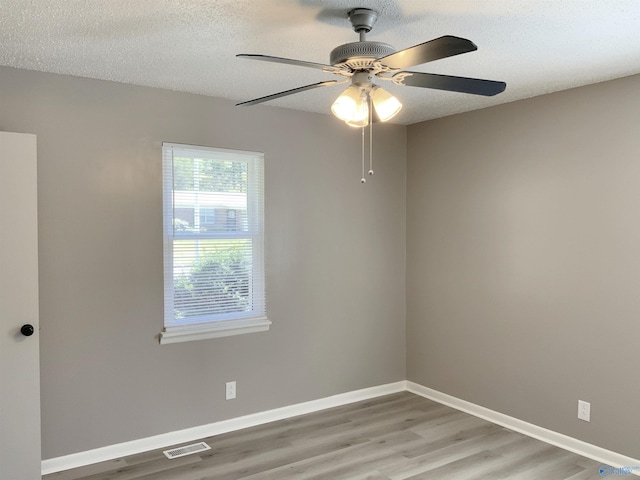 empty room featuring light hardwood / wood-style floors, a textured ceiling, and ceiling fan