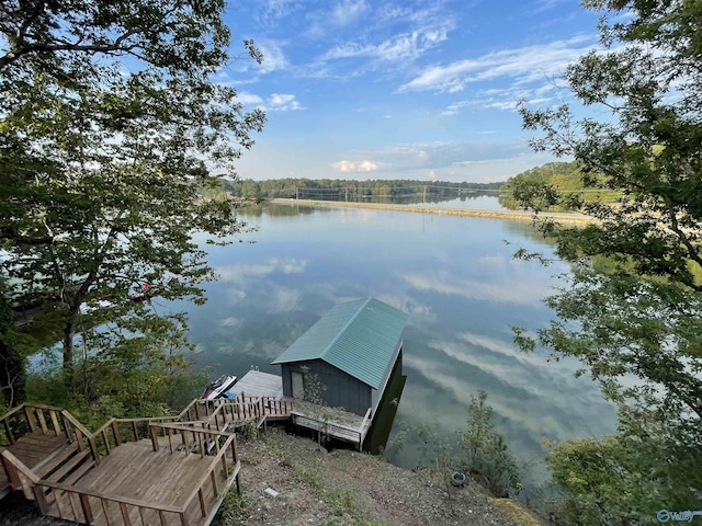 view of dock with a water view and a wooded view