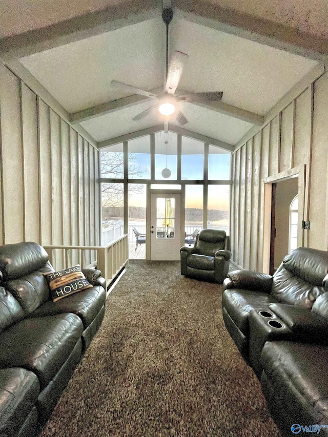 carpeted living room featuring ceiling fan and lofted ceiling with beams