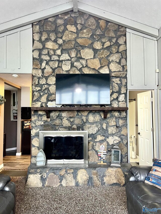 living room featuring a stone fireplace, baseboards, and lofted ceiling
