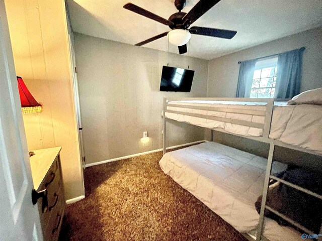 carpeted bedroom featuring baseboards and a ceiling fan