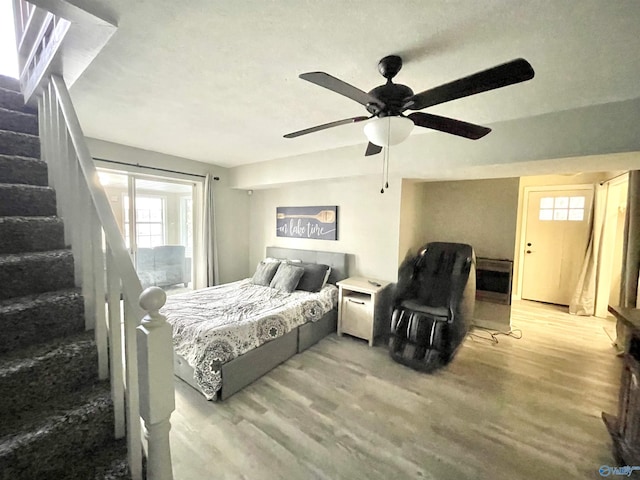 bedroom with multiple windows, wood finished floors, and a ceiling fan