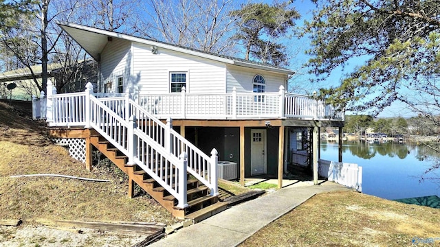 exterior space with central AC, a deck with water view, and stairway