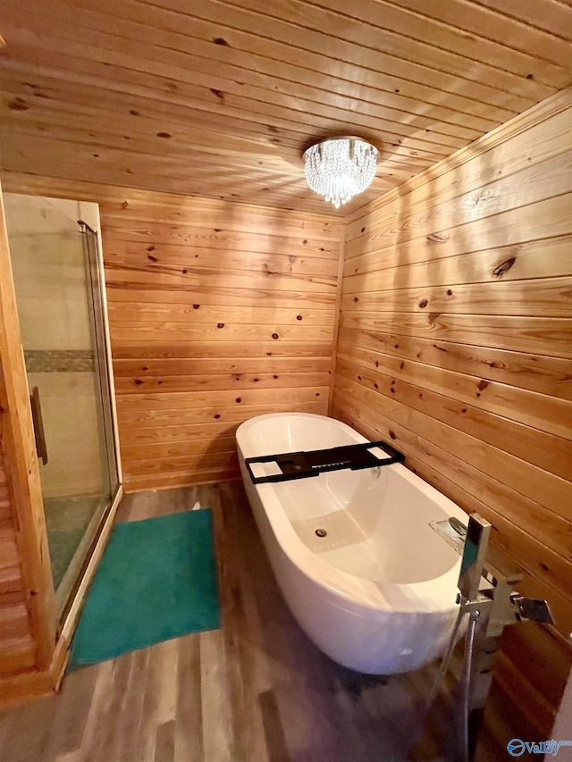 full bathroom featuring a stall shower, a soaking tub, wood walls, wooden ceiling, and wood finished floors