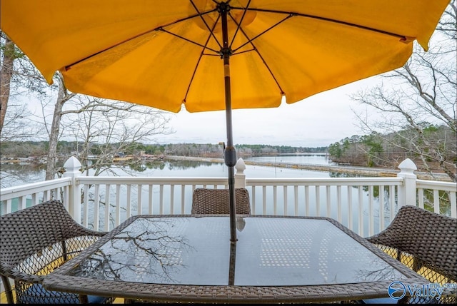wooden terrace with outdoor dining space and a water view