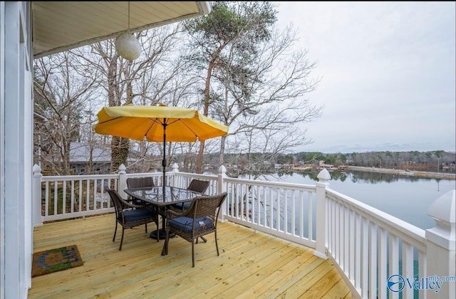 deck featuring outdoor dining area and a water view