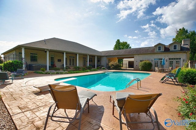 view of swimming pool with french doors, a diving board, and a patio area