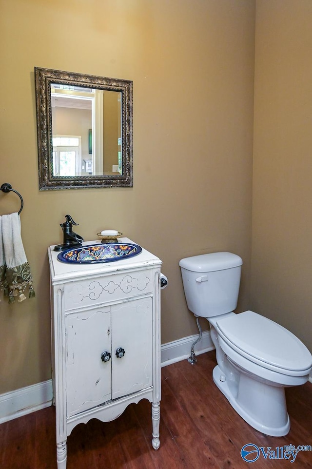 bathroom featuring vanity, hardwood / wood-style flooring, and toilet