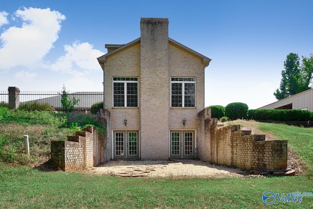 back of property with a yard and french doors