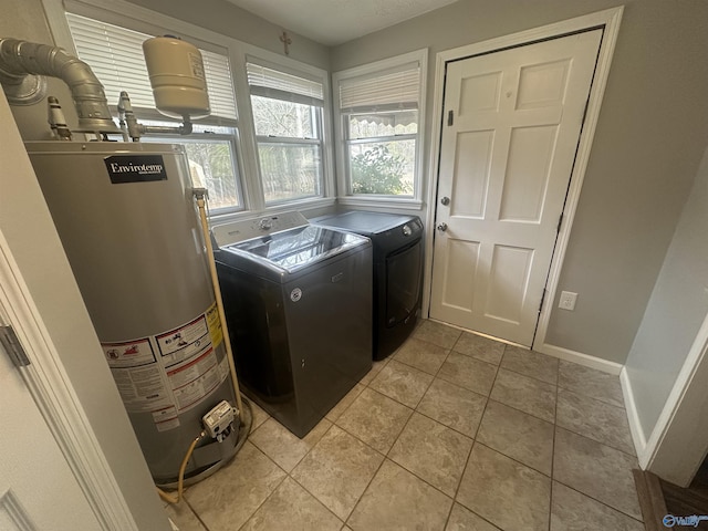 laundry room featuring light tile patterned flooring, washer and clothes dryer, and water heater