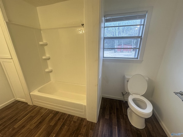 bathroom featuring toilet, wood-type flooring, and bathtub / shower combination