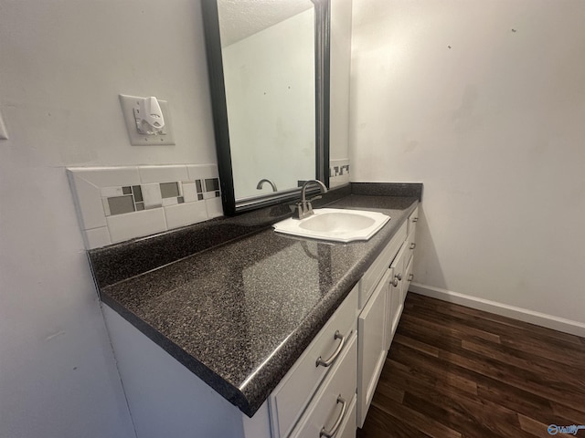 bathroom featuring decorative backsplash, vanity, a textured ceiling, and hardwood / wood-style flooring