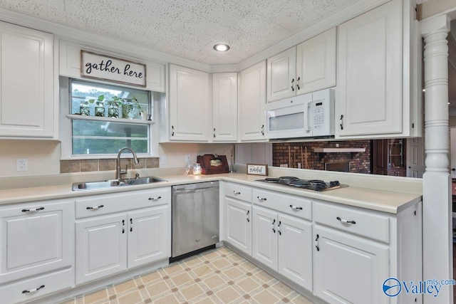 kitchen with ornate columns, appliances with stainless steel finishes, sink, and white cabinets