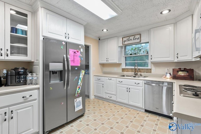 kitchen featuring sink, appliances with stainless steel finishes, a textured ceiling, and white cabinetry