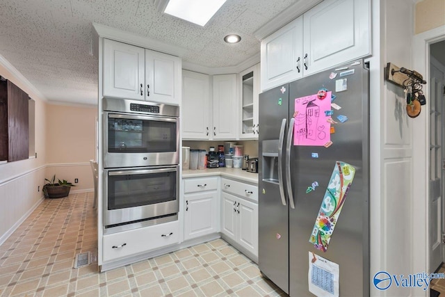 kitchen featuring appliances with stainless steel finishes, crown molding, and white cabinetry