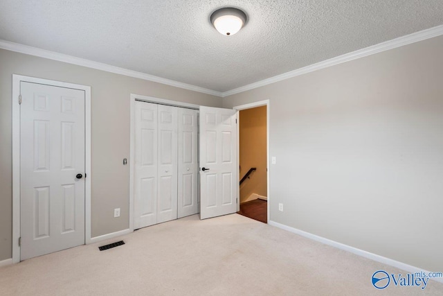 unfurnished bedroom featuring crown molding, light carpet, and a textured ceiling