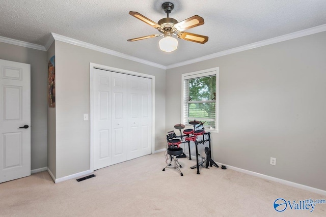 carpeted office space with ceiling fan, ornamental molding, and a textured ceiling