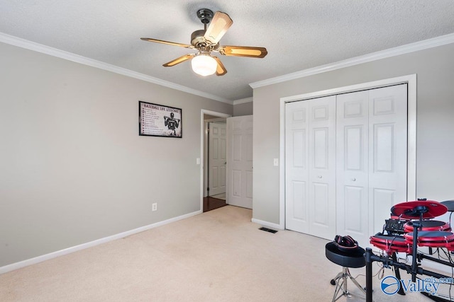 rec room with a textured ceiling, ornamental molding, light colored carpet, and ceiling fan