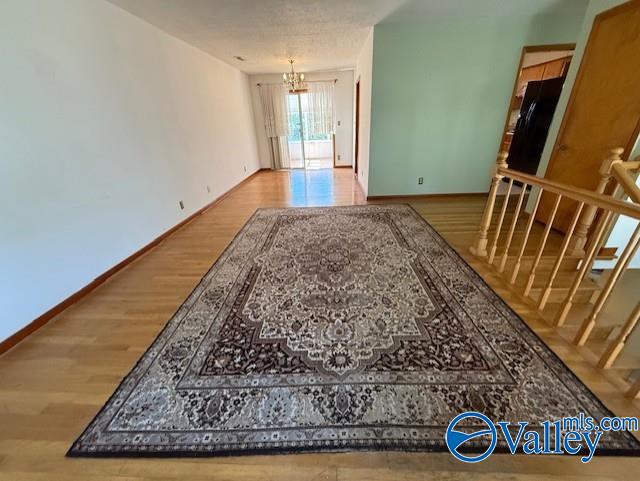 interior space with stairway, an inviting chandelier, wood finished floors, and baseboards