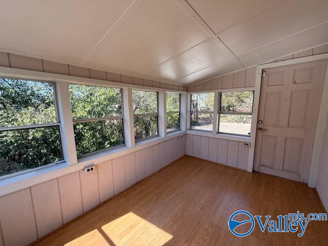 unfurnished sunroom featuring vaulted ceiling