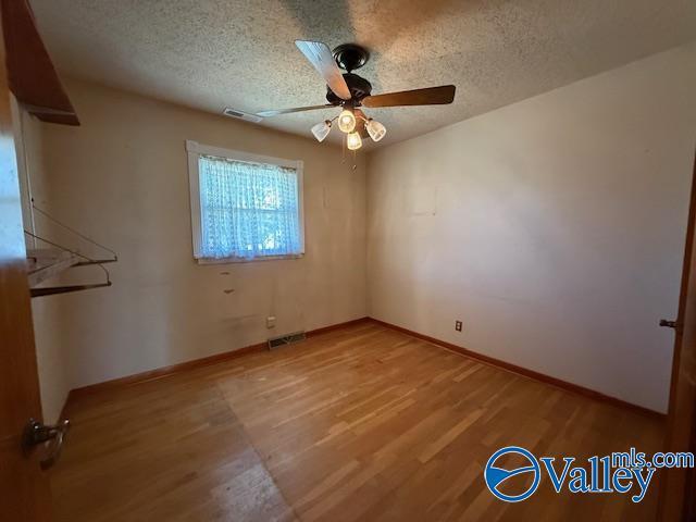 unfurnished bedroom with light wood-type flooring, visible vents, and a textured ceiling