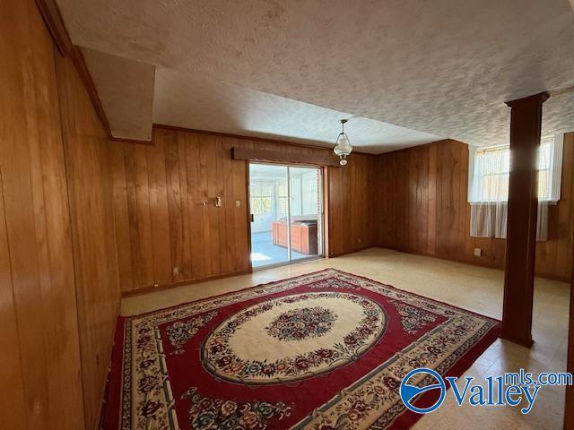 interior space with wood walls and a textured ceiling