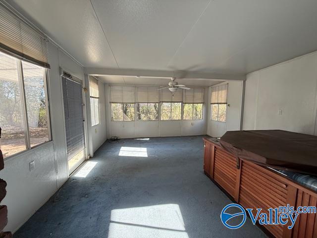 sunroom featuring a healthy amount of sunlight and a ceiling fan