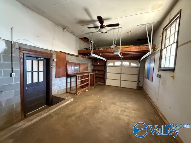 garage with concrete block wall and a garage door opener