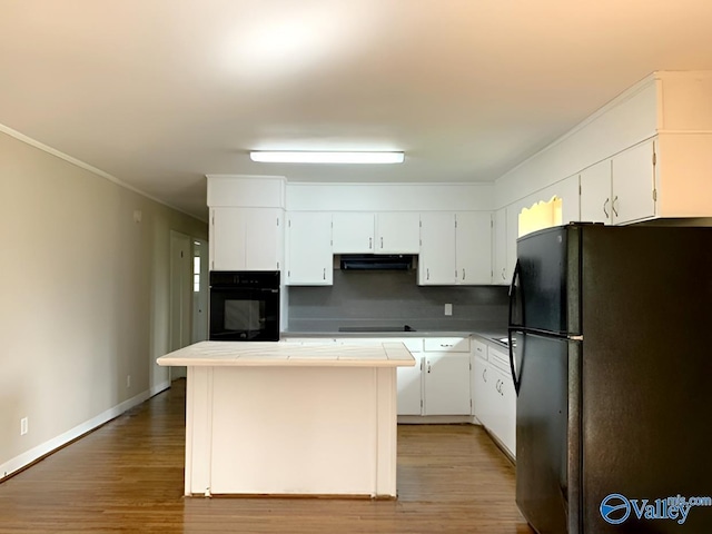 kitchen featuring black appliances, decorative backsplash, white cabinets, and tile countertops