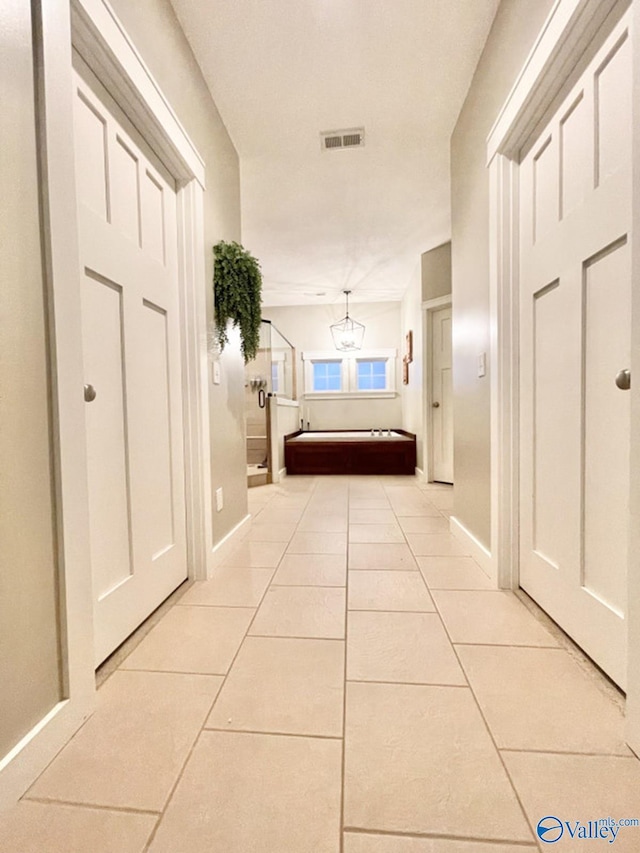 corridor with light tile patterned flooring