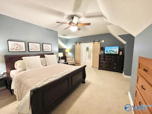 bedroom with light carpet, ceiling fan, vaulted ceiling, and a barn door