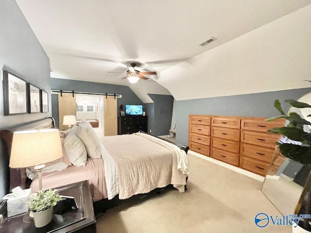 bedroom featuring vaulted ceiling, ceiling fan, carpet flooring, and a barn door