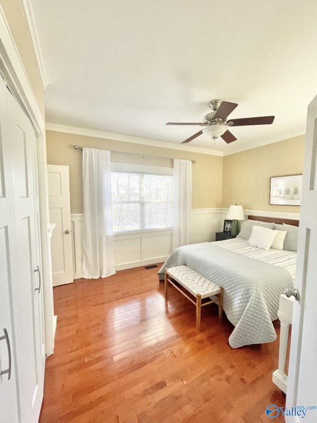 bedroom with ceiling fan, hardwood / wood-style floors, and crown molding