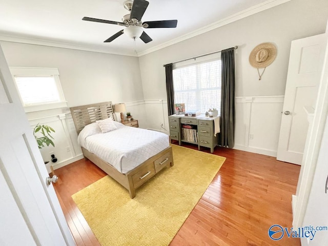 bedroom with ceiling fan, ornamental molding, light hardwood / wood-style floors, and multiple windows