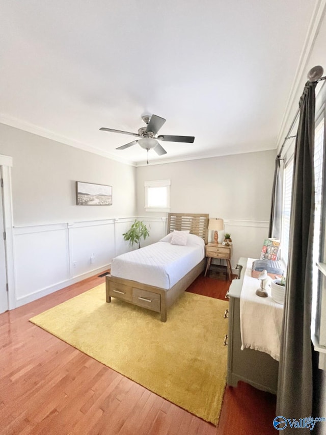 bedroom featuring ceiling fan, ornamental molding, and hardwood / wood-style flooring