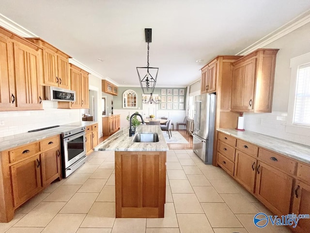 kitchen with stainless steel appliances, decorative light fixtures, a kitchen island with sink, crown molding, and sink