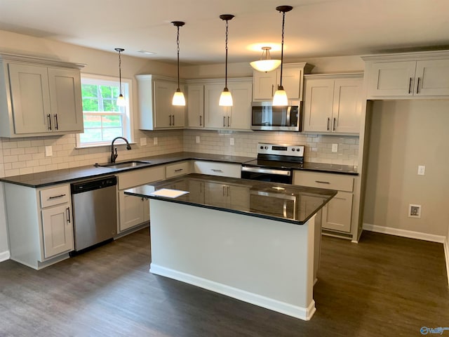 kitchen with hanging light fixtures, sink, dark hardwood / wood-style floors, and stainless steel appliances