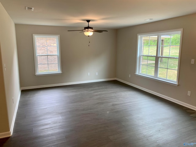 empty room featuring dark wood-type flooring and ceiling fan