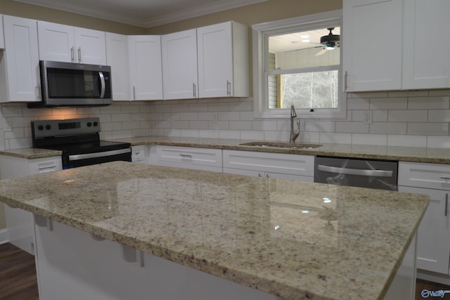 kitchen with light stone countertops, appliances with stainless steel finishes, and white cabinets