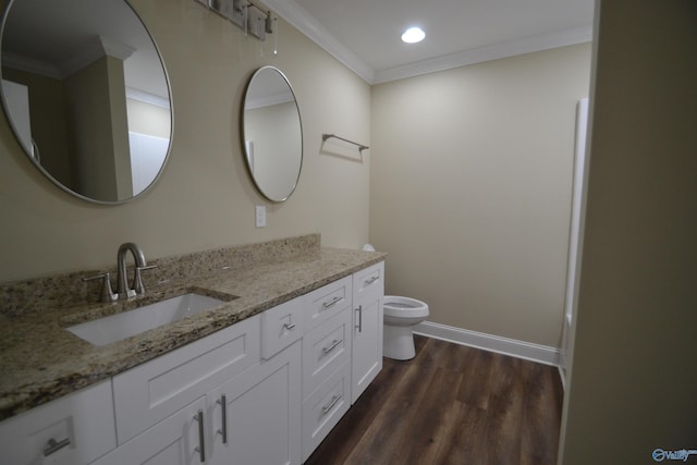 bathroom featuring vanity, hardwood / wood-style floors, ornamental molding, and toilet