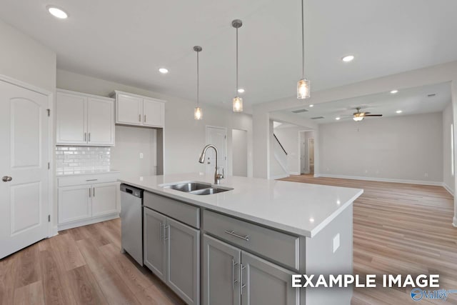 kitchen featuring sink, dishwasher, hanging light fixtures, a center island with sink, and decorative backsplash