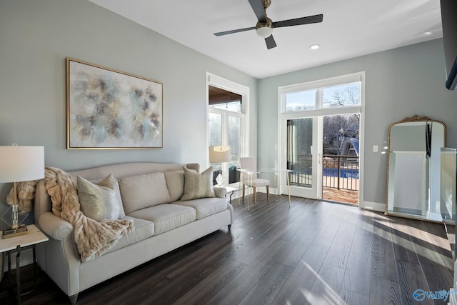 living area with dark wood finished floors, baseboards, and a ceiling fan