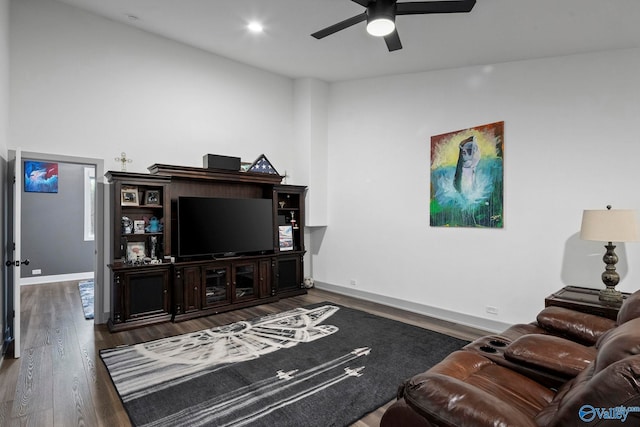 living room featuring baseboards, a ceiling fan, and wood finished floors